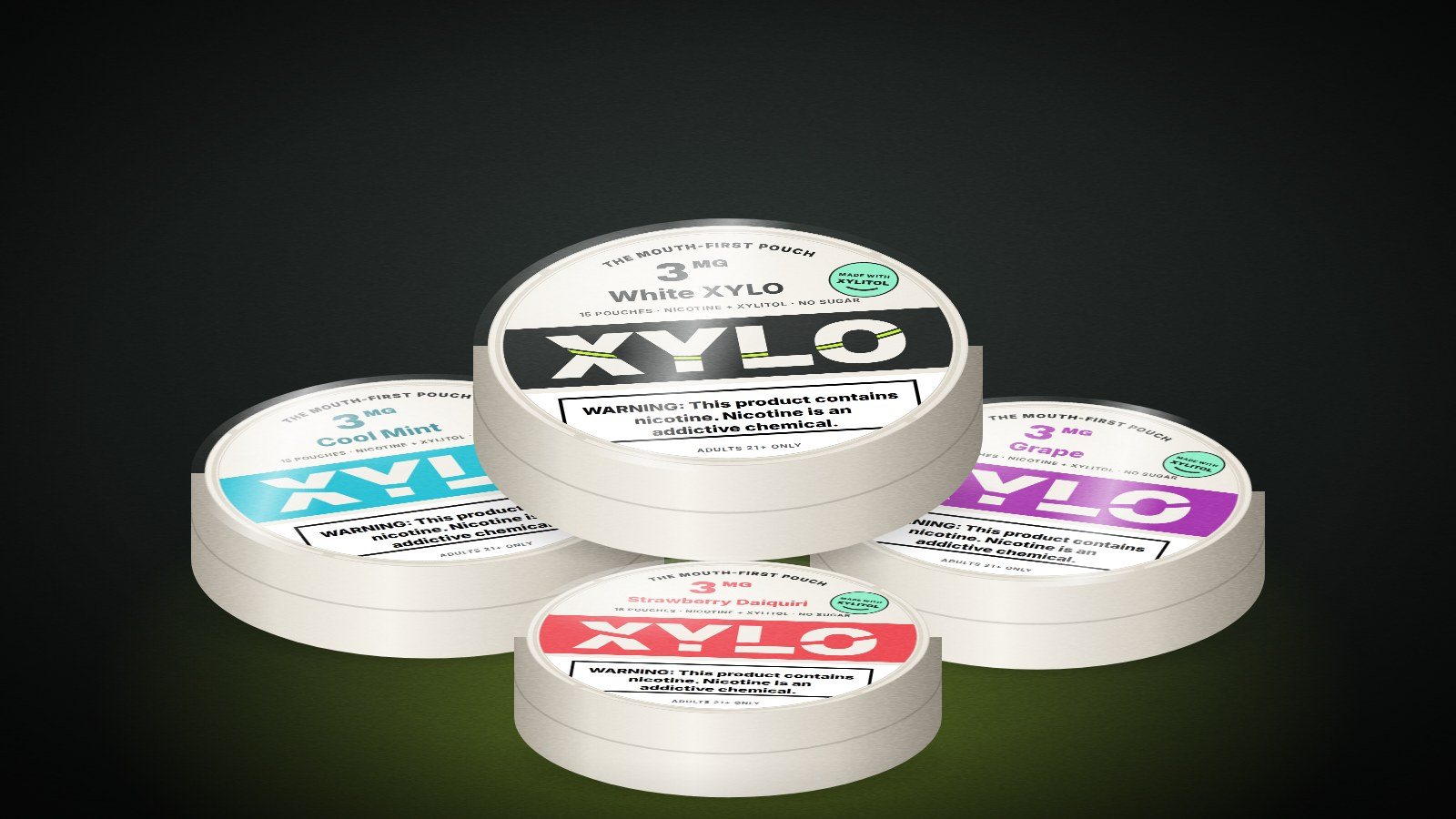 Four revamped XYLO cans: White XYLO, Cool Mint, Grape and Strawberry Daiquiri, each with a smile cut through the wordmark and The Mouth-First Pouch around the lid